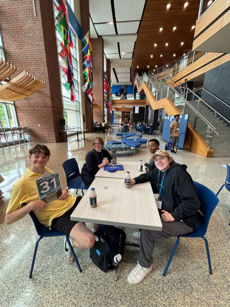 Students in Group 31 of orientation posing for a photo in the Student Union with their Student Orientation Assistant, holding bottles of MTSU chocolate milk.
