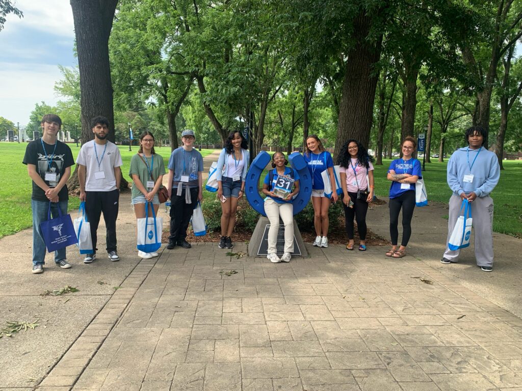 Students in Group 31 of orientation posing for a photo at the blue horseshoe at MTSU with their Student Orientation Assistant.