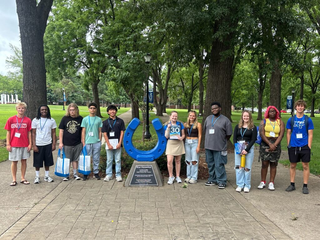 Students in Group 30 of orientation posing for a photo at the blue horseshoe at MTSU with their Student Orientation Assistant.
