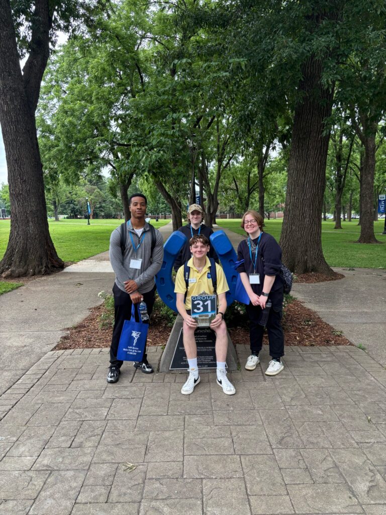 Students in Group 31 of orientation posing for a photo at the blue horseshoe at MTSU with their Student Orientation Assistant.