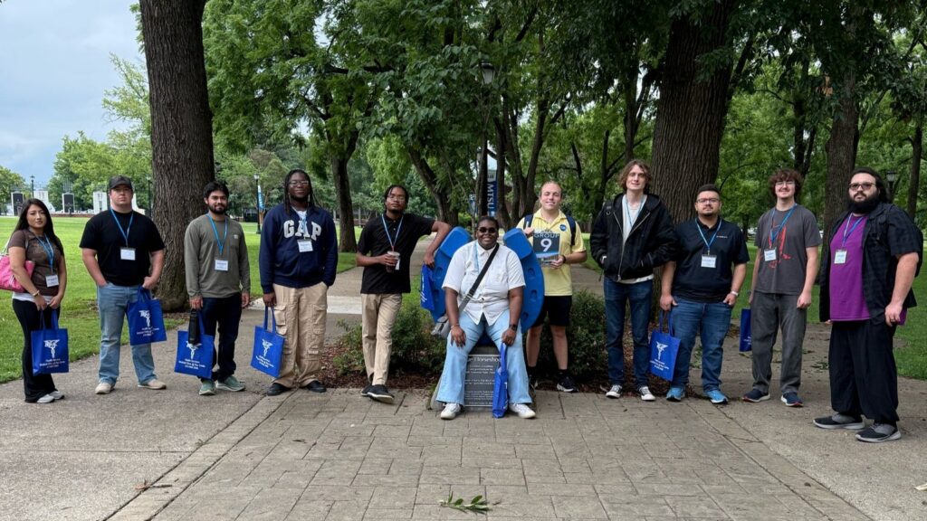 Students in Group 9 of orientation posing for a photo at the blue horseshoe at MTSU with their Student Orientation Assistant.