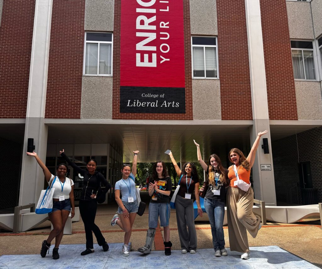 Seven students posing for a picture at Peck Hall.