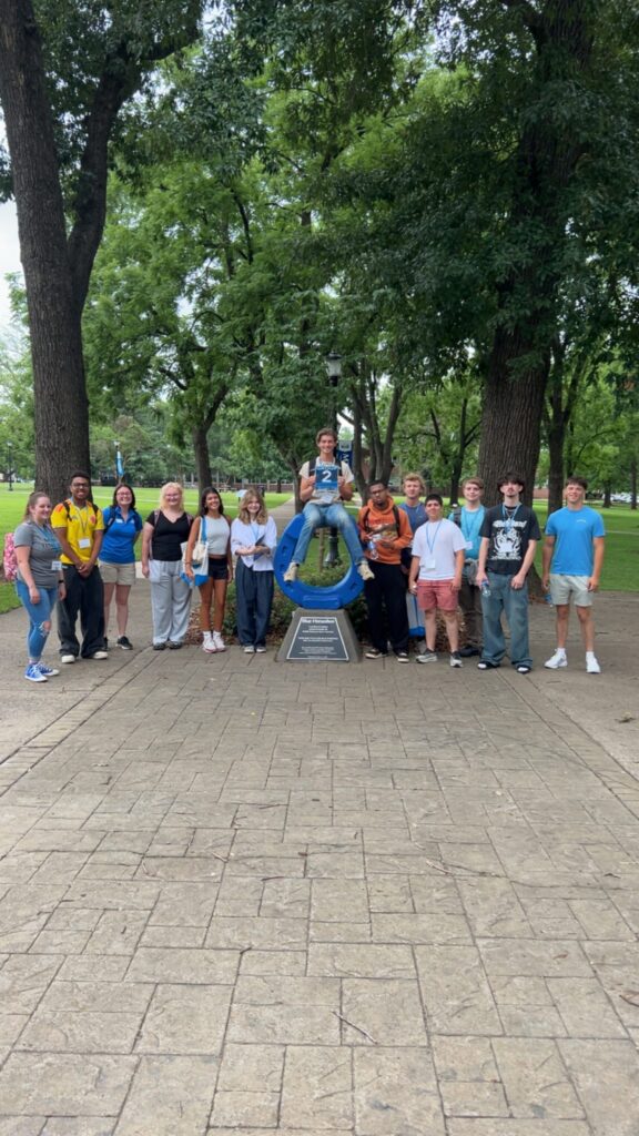 Students in Group 2 of orientation posing for a photo at the blue horseshoe at MTSU with their Student Orientation Assistant.