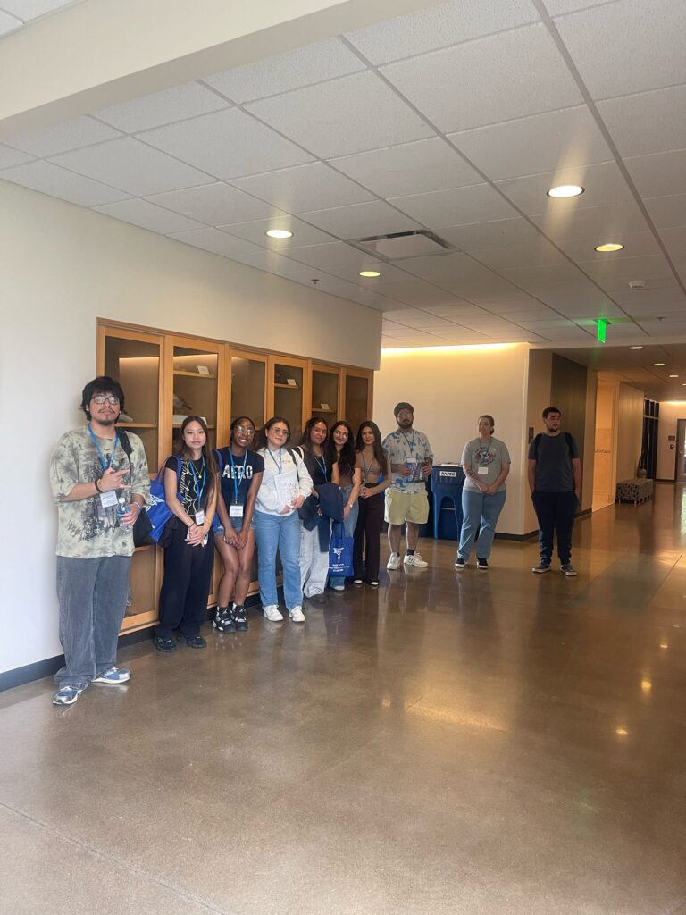 Students attending orientation posing together inside a campus building.