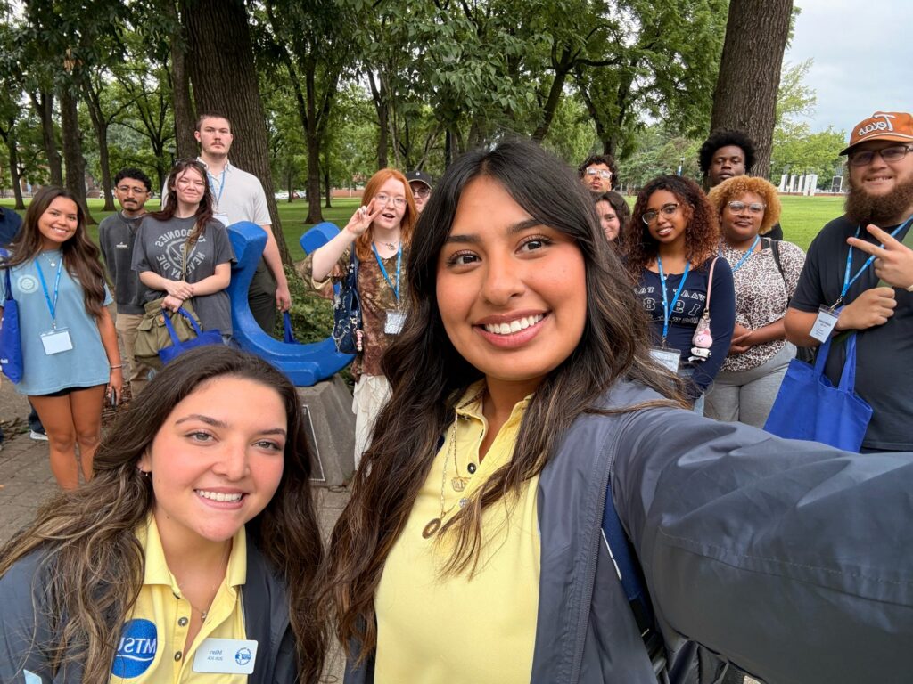 Students attending orientation posing for a photo in Walnut Grove at MTSU with their Student Orientation Assistants.