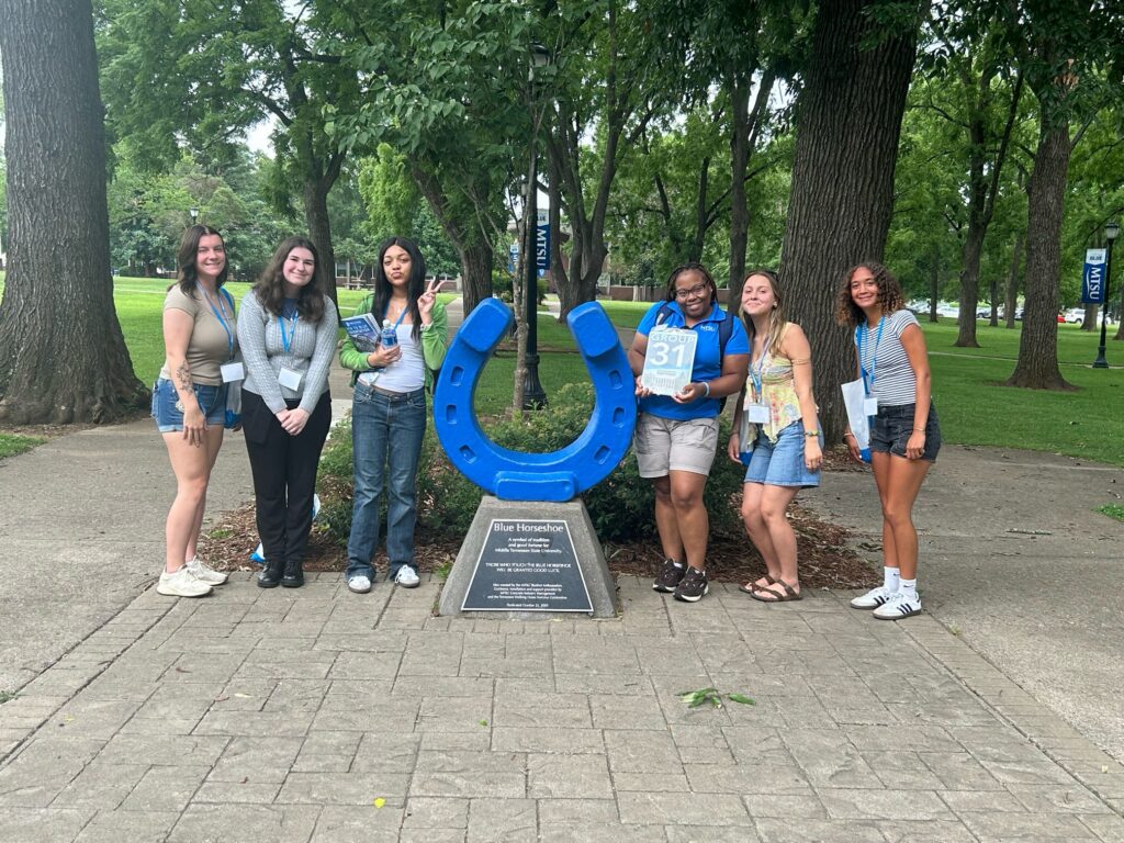 Students in Group 31 of orientation posing for a photo at the blue horseshoe at MTSU with their Student Orientation Assistant.