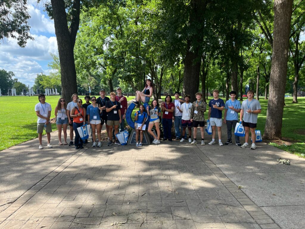 Students in Group 7 of orientation posing for a photo at the blue horseshoe at MTSU with their Student Orientation Assistant.