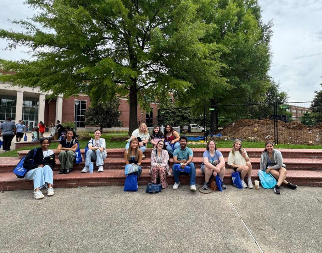 Students attending orientation posing for a photo outside the Business and Aerospace Building.