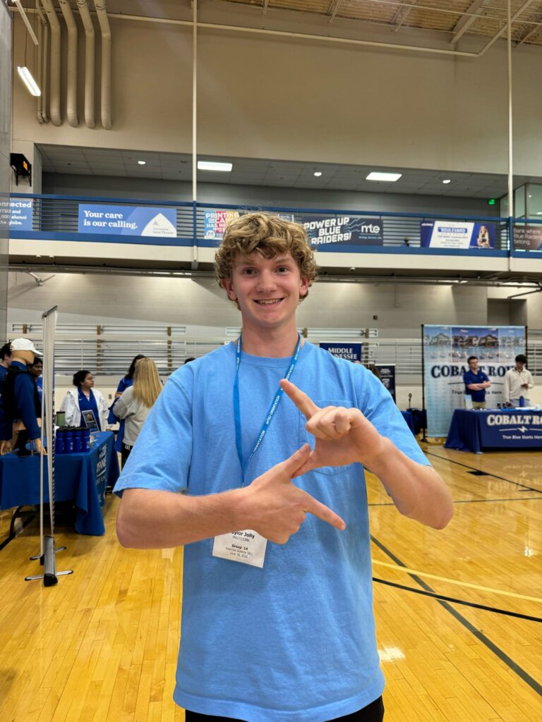 Student attending orientation forming a lightning symbol with their hands