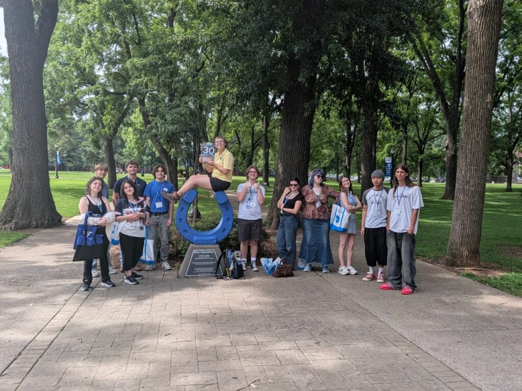 Students in Group 30 of orientation posing for a photo at the blue horseshoe at MTSU with their Student Orientation Assistant.