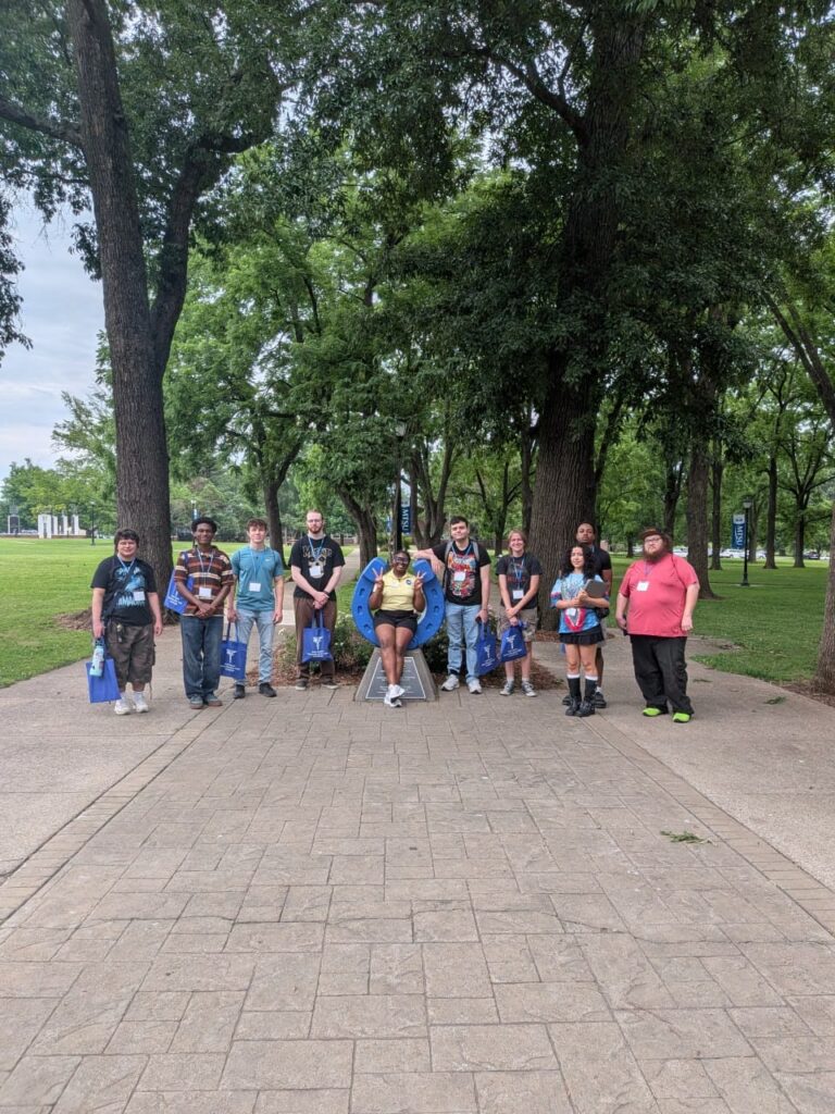 Students attending orientation posing for a photo at the blue horseshoe at MTSU with their Student Orientation Assistant.