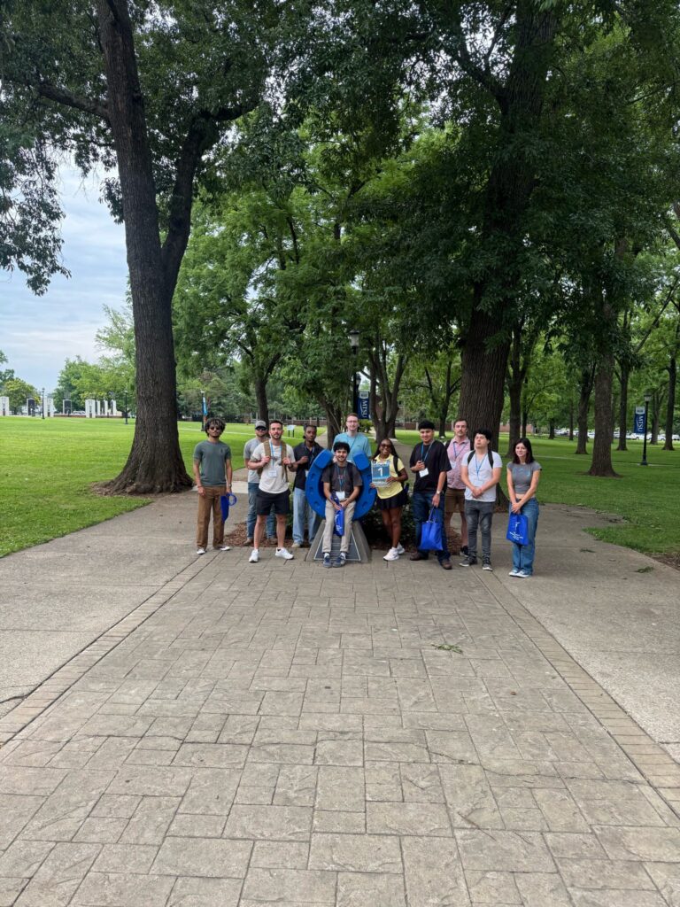 Students in Group 1 of orientation posing for a photo at the blue horseshoe at MTSU with their Student Orientation Assistant.