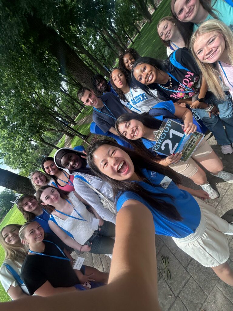 Students in Group 21 of orientation posing for a photo at the blue horseshoe at MTSU with their Student Orientation Assistant.