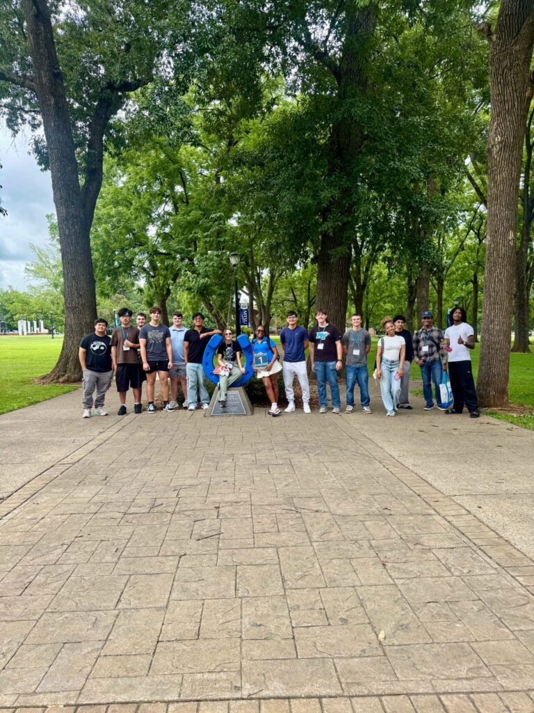 Students in Group 1 of orientation posing for a photo at the blue horseshoe at MTSU with their Student Orientation Assistant.