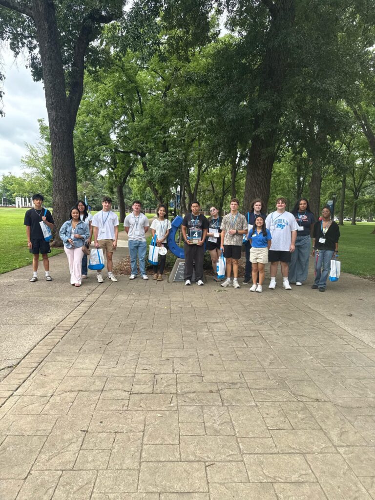Students in Group 4 of orientation posing for a photo at the blue horseshoe at MTSU with their Student Orientation Assistant.