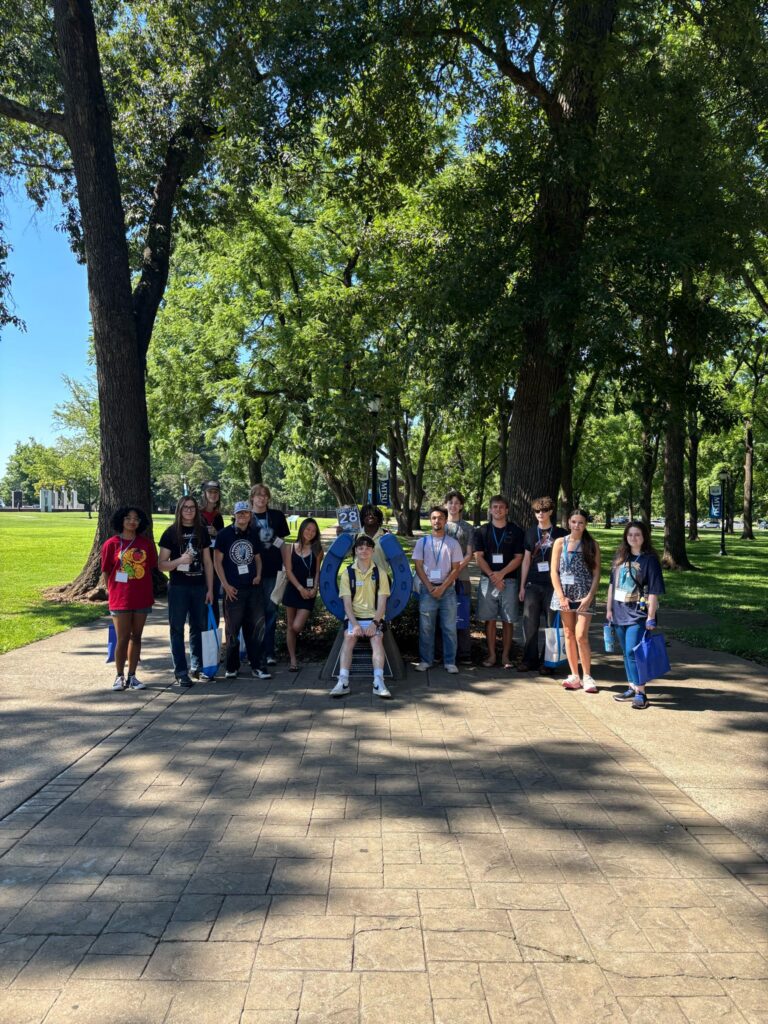Students in Group 28 of orientation posing for a photo at the blue horseshoe at MTSU with their Student Orientation Assistant.