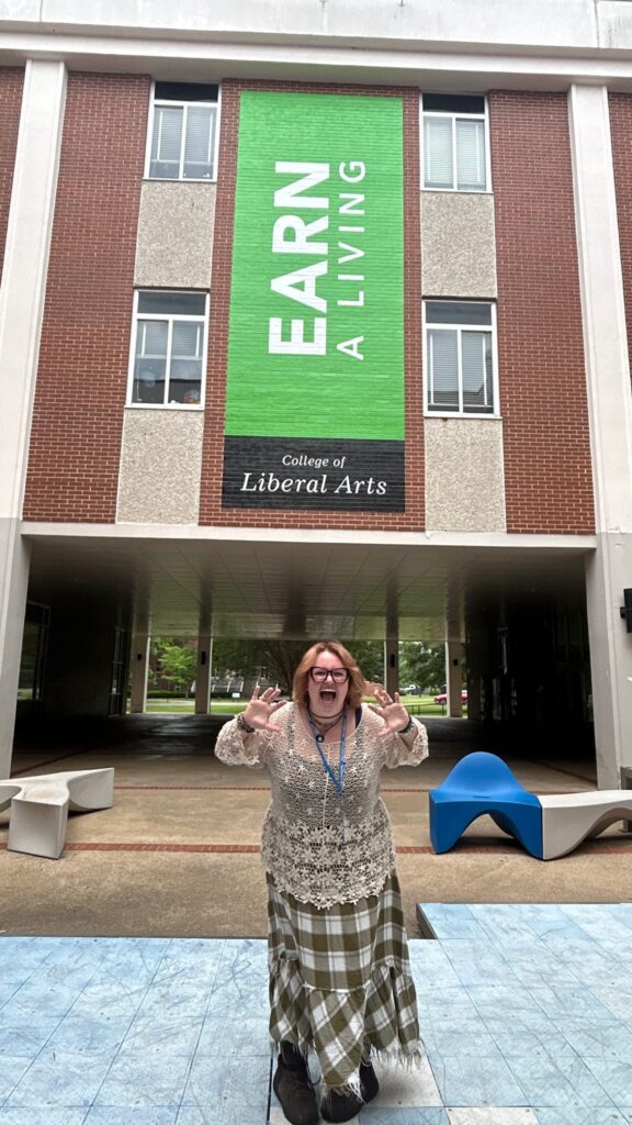 Student attending New to Blue Orientation posing at the center of Peck Hall.