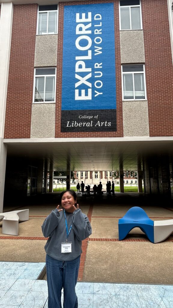 Student attending New to Blue Orientation posing at the center of Peck Hall.
