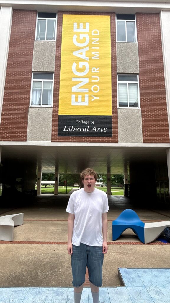 Student attending New to Blue Orientation posing at the center of Peck Hall.