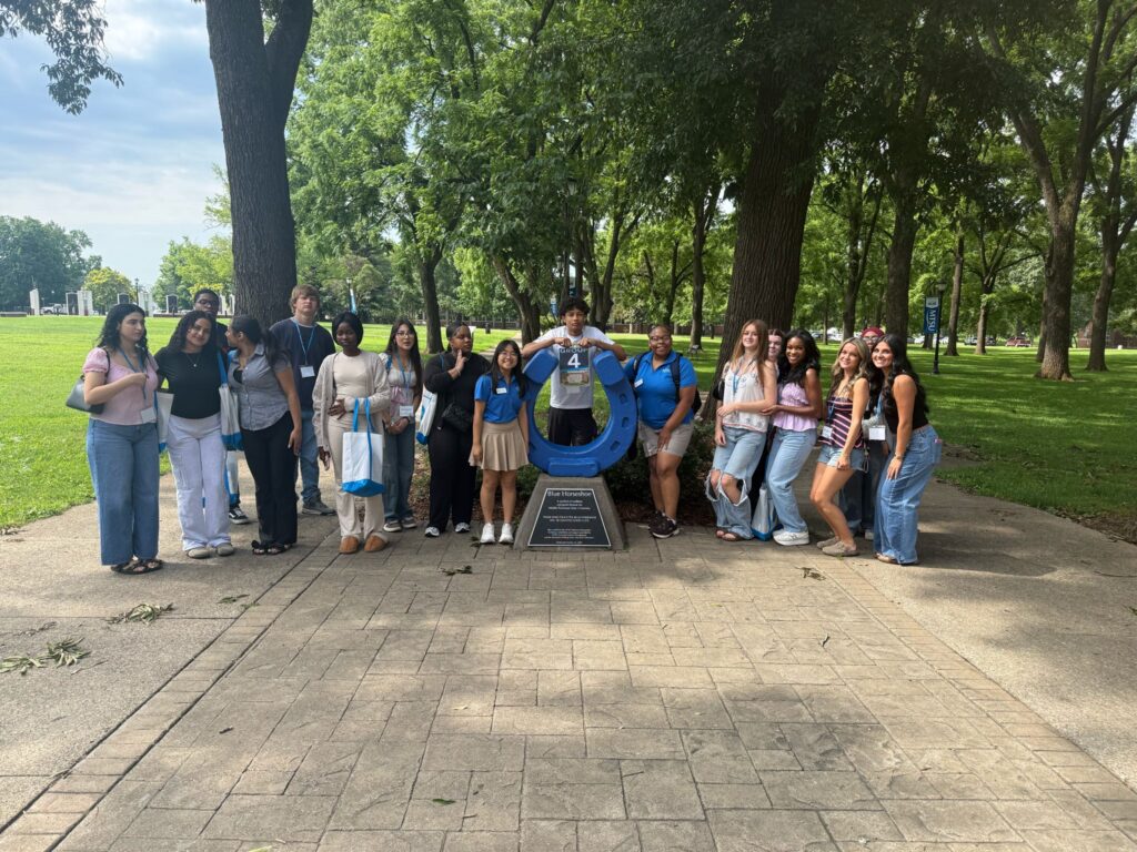 Students in Group 4 of orientation posing for a photo at the blue horseshoe at MTSU with their Student Orientation Assistant.