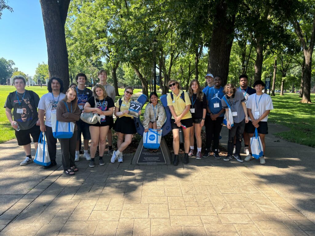 Students in Group 27 of orientation posing for a photo at the blue horseshoe at MTSU with their Student Orientation Assistant.