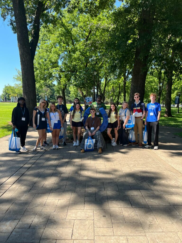 Students in Group 29 of orientation posing for a photo at the blue horseshoe at MTSU with their Student Orientation Assistant.