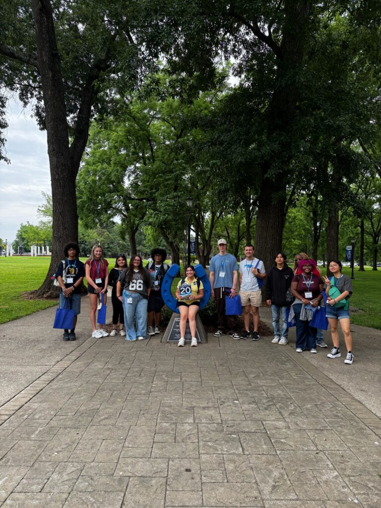 Students in Group 20 of orientation posing for a photo at the blue horseshoe at MTSU with their Student Orientation Assistant.