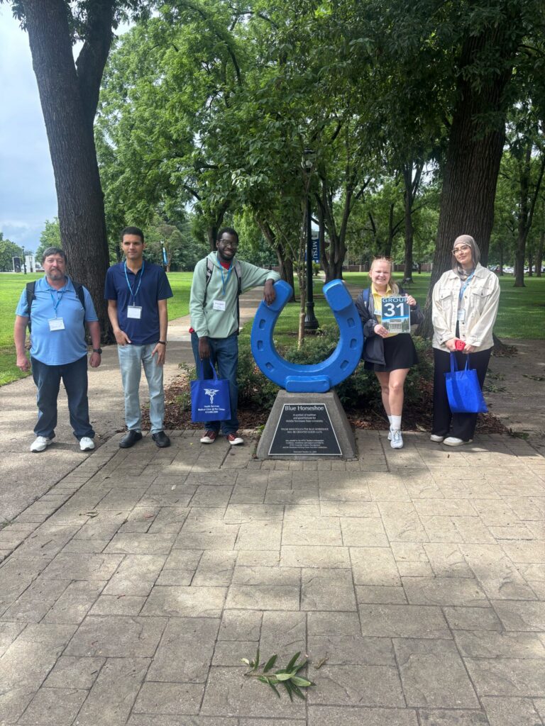 Students in Group 31 of orientation posing for a photo at the blue horseshoe at MTSU with their Student Orientation Assistant.
