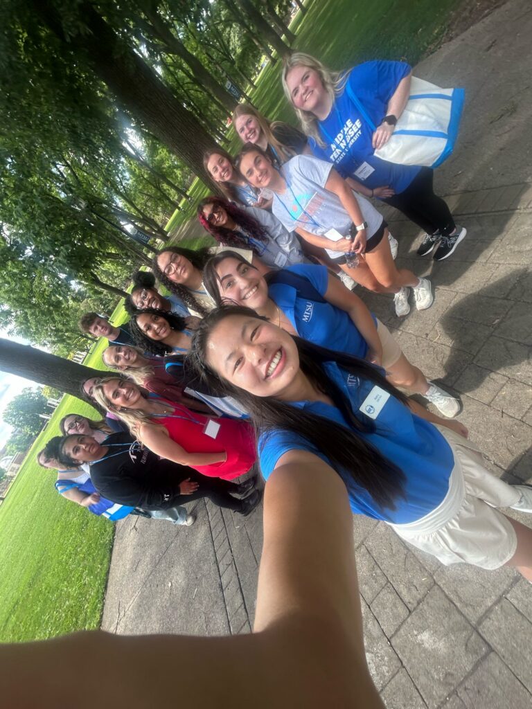 Students attending orientation posing for a photo in Walnut Grove with their Student Orientation Assistant.