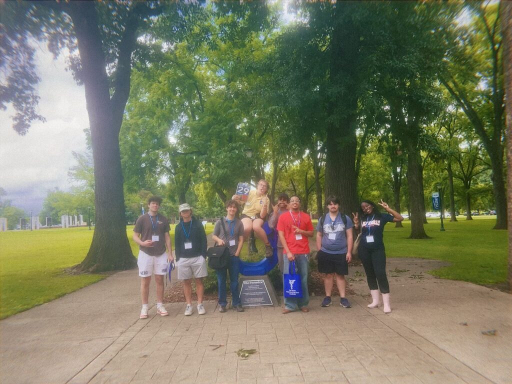 Students in Group 29 of orientation posing for a photo at the blue horseshoe at MTSU with their Student Orientation Assistant.