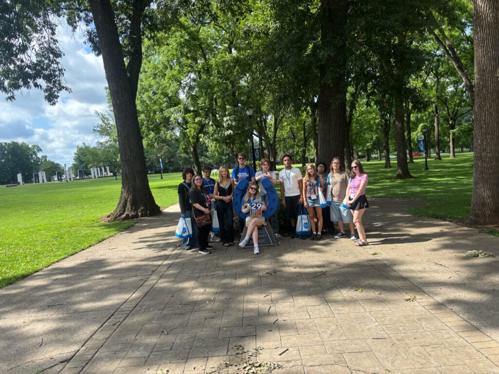 Students in Group 29 of orientation posing for a photo at the blue horseshoe at MTSU with their Student Orientation Assistant.