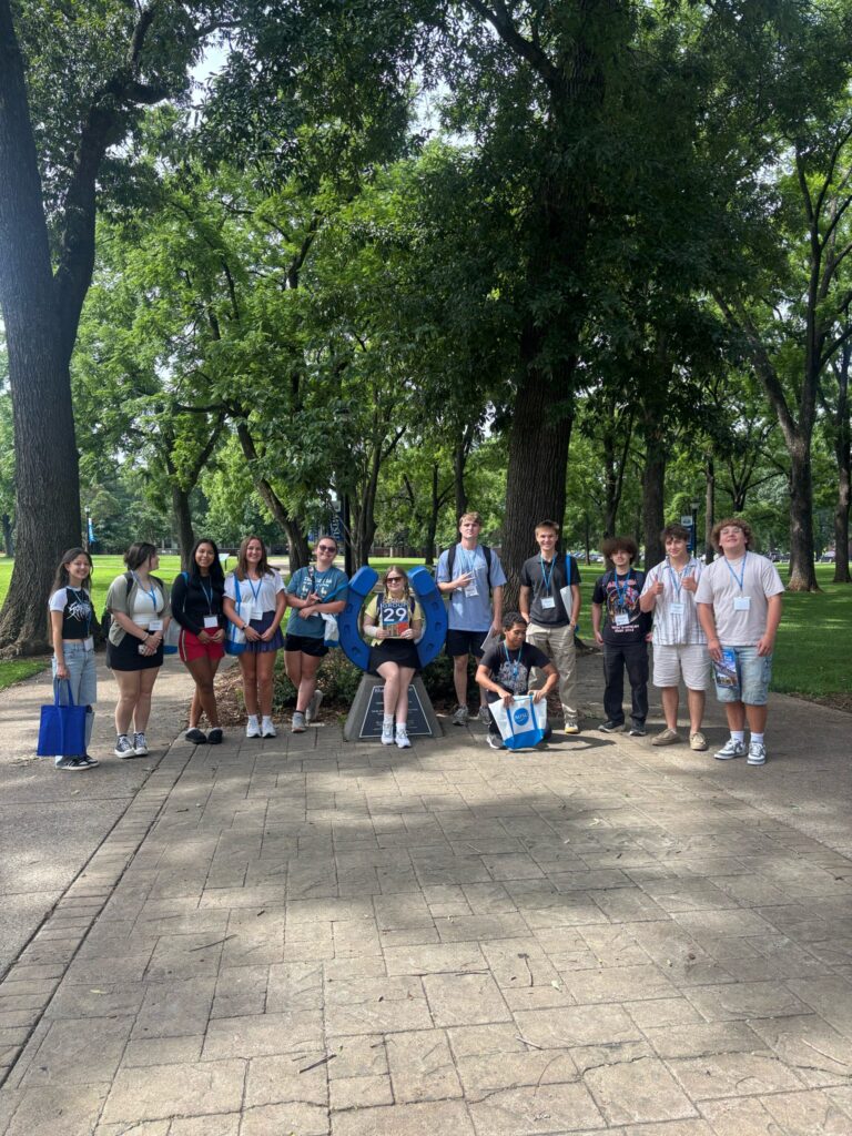 Students in Group 29 of orientation posing for a photo at the blue horseshoe at MTSU with their Student Orientation Assistant.