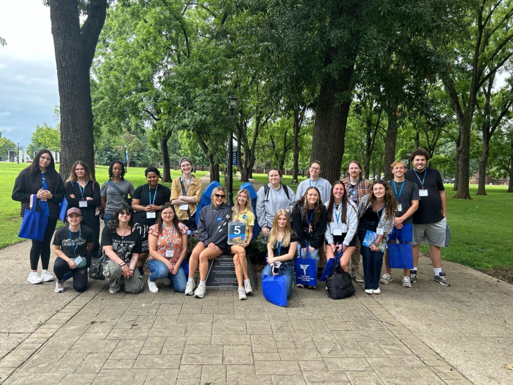 Students in Group 5 of orientation posing for a photo at the blue horseshoe at MTSU with their Student Orientation Assistants.