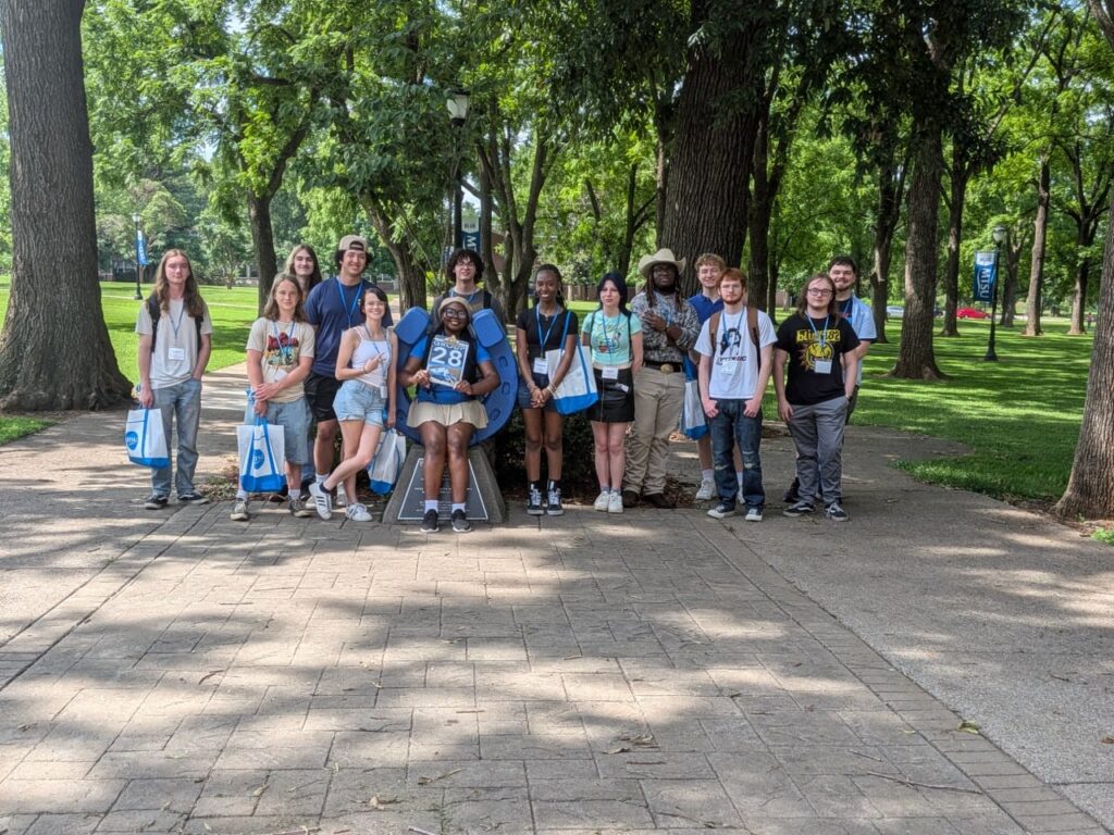 Students in Group 28 of orientation posing for a photo at the blue horseshoe at MTSU with their Student Orientation Assistant.
