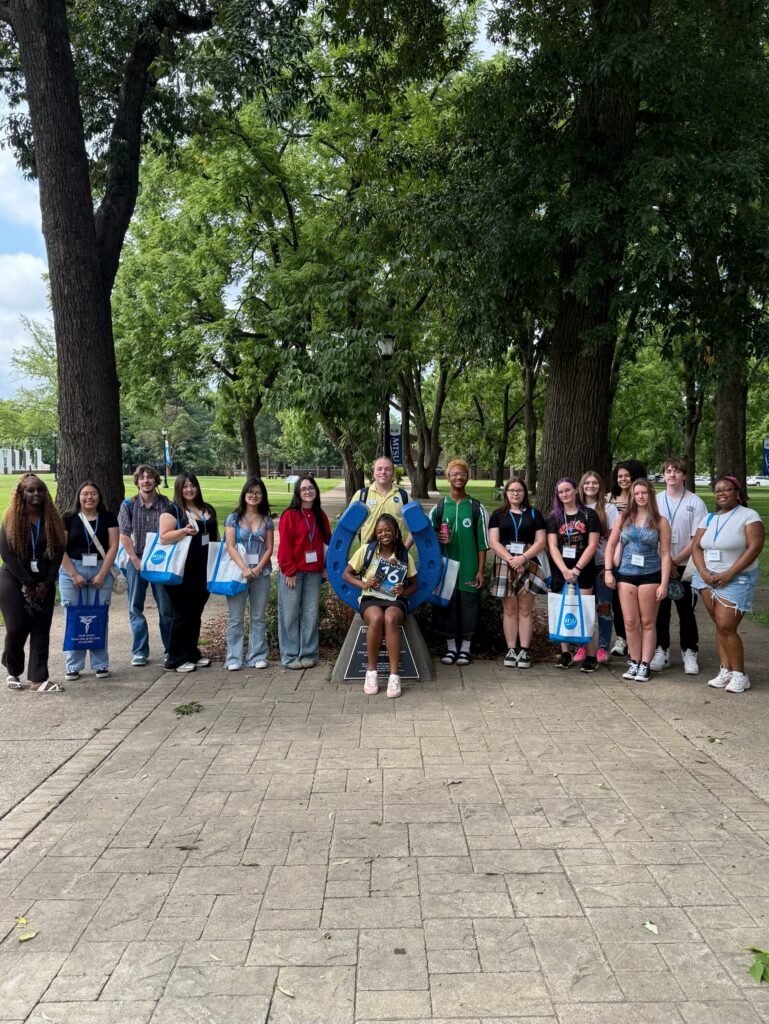 Students in Group 16 of orientation posing for a photo at the blue horseshoe at MTSU with their Student Orientation Assistants.