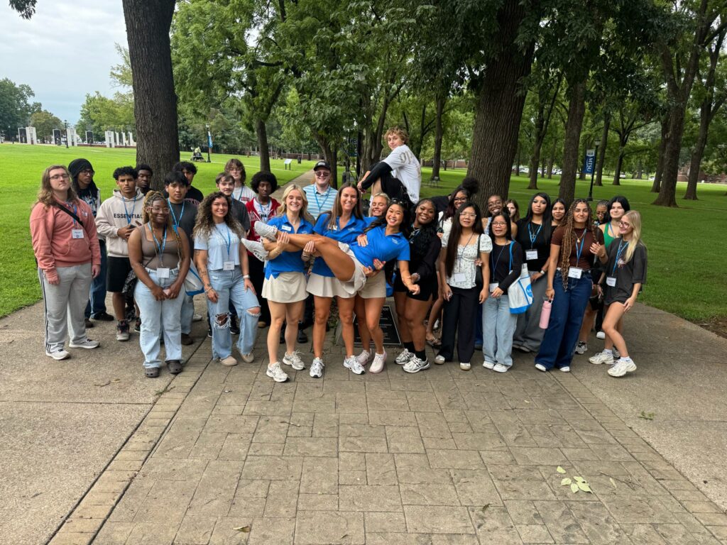 Students in multiple orientation groups posing for a photo at the blue horseshoe at MTSU with their Student Orientation Assistanta.