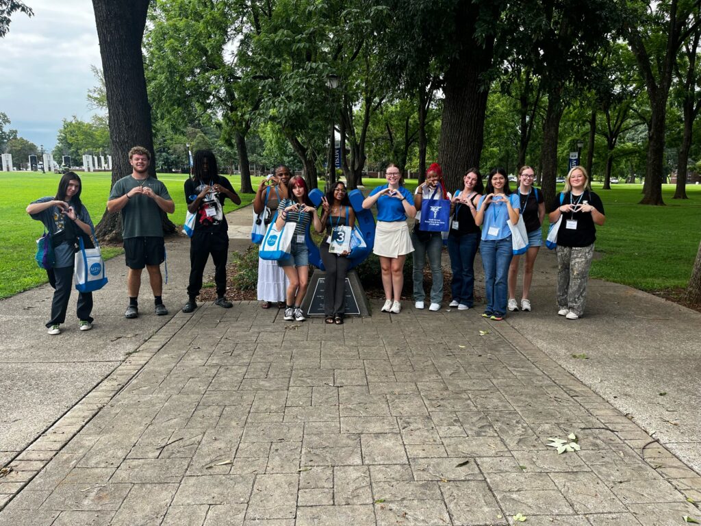 Students in Group 3 of orientation posing for a photo at the blue horseshoe at MTSU with their Student Orientation Assistant.