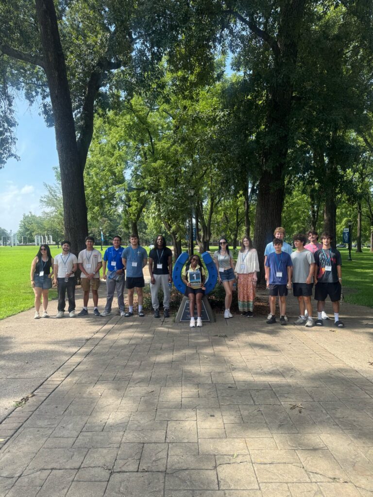 Students in Group 1 of orientation posing for a photo at the blue horseshoe at MTSU with their Student Orientation Assistant.