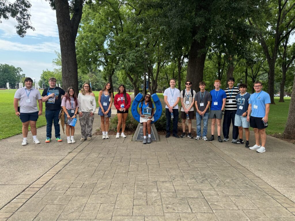 Students in Group 1 of orientation posing for a photo at the blue horseshoe at MTSU with their Student Orientation Assistant.