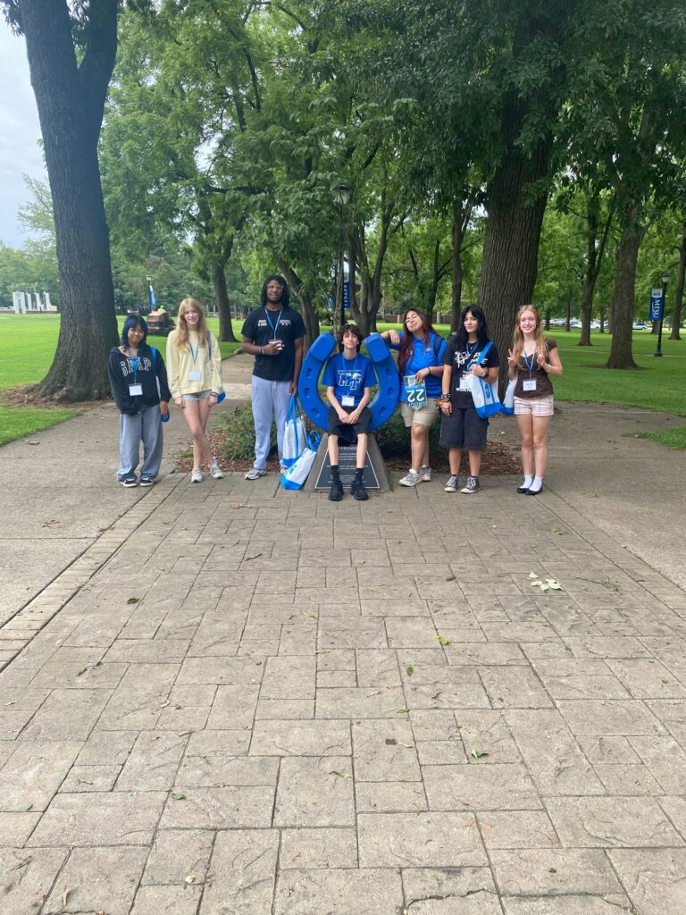 Students in Group 22 of orientation posing for a photo at the blue horseshoe at MTSU with their Student Orientation Assistant.
