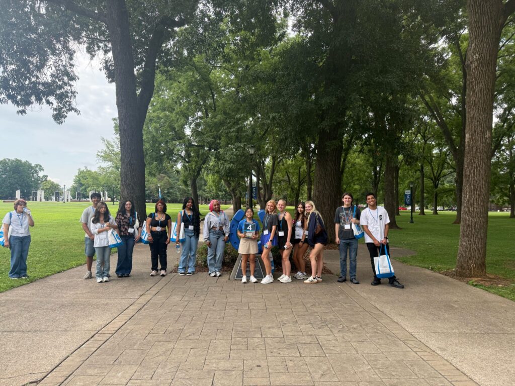 Students in Group 4 of orientation posing for a photo at the blue horseshoe at MTSU with their Student Orientation Assistant.