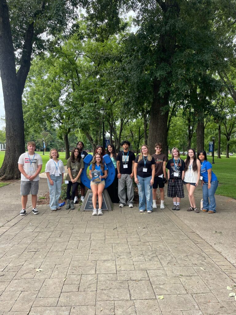 Students in Group 5 of orientation posing for a photo at the blue horseshoe at MTSU with their Student Orientation Assistant.