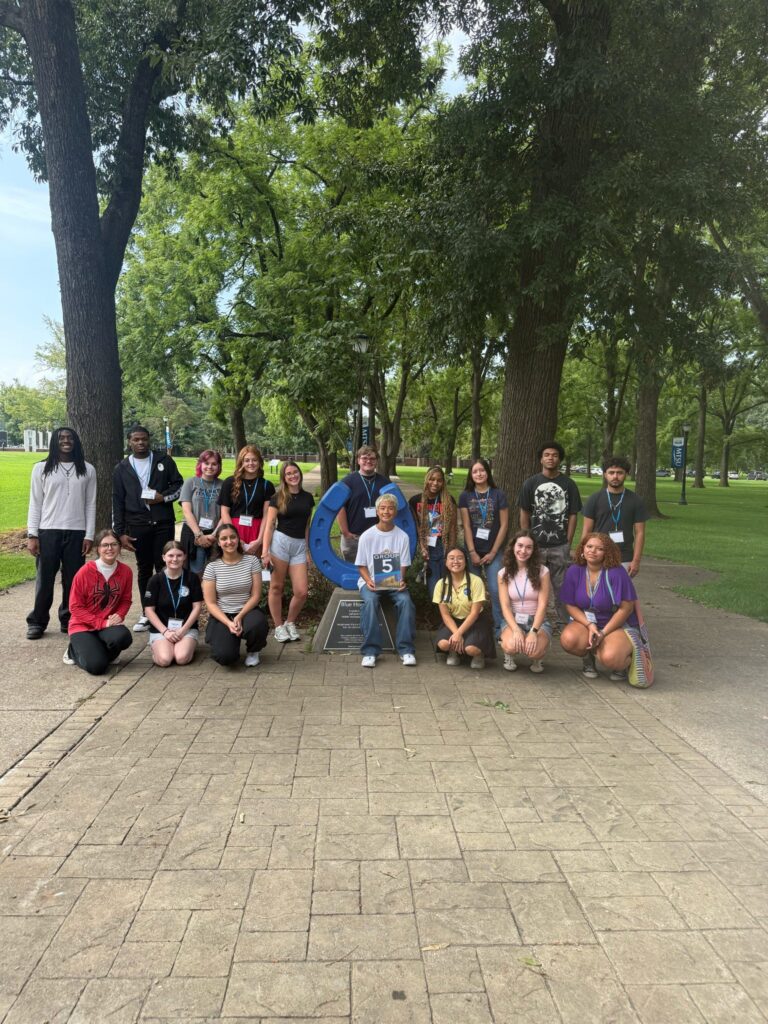 Students in Group 15 of orientation posing for a photo at the blue horseshoe at MTSU with their Student Orientation Assistant.