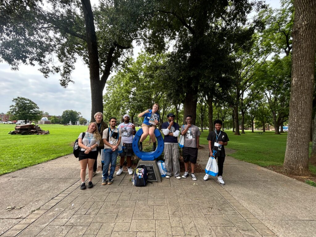 Students in Group 30 of orientation posing for a photo at the blue horseshoe at MTSU with their Student Orientation Assistant.