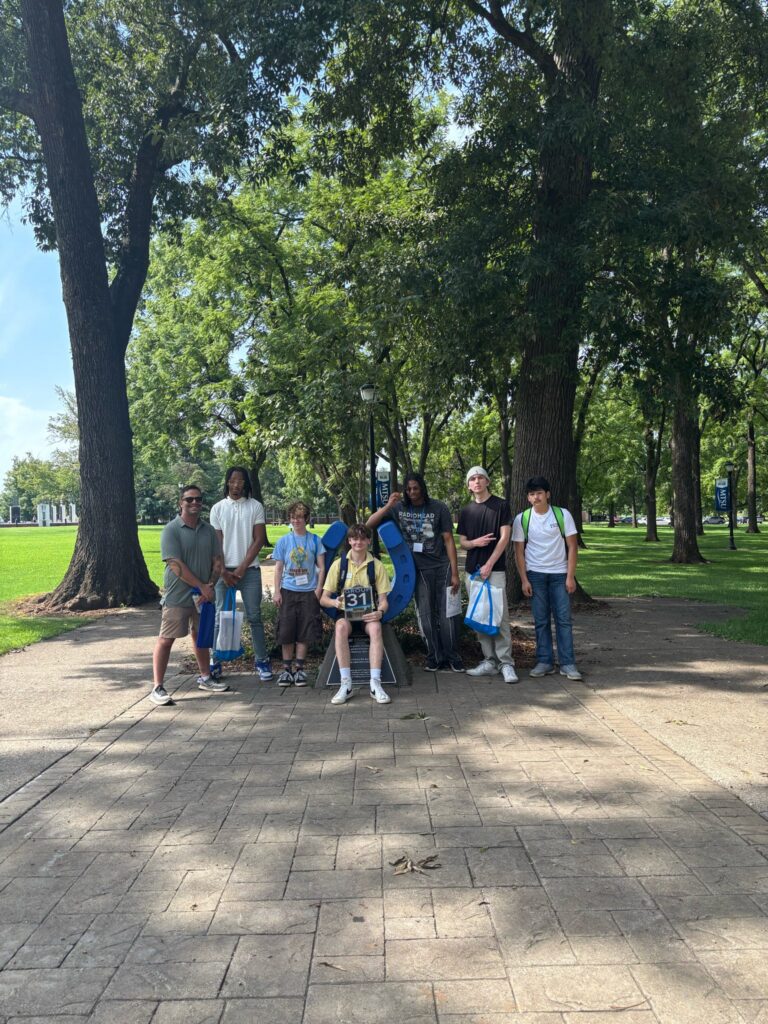Students in Group 31 of orientation posing for a photo at the blue horseshoe at MTSU with their Student Orientation Assistant.