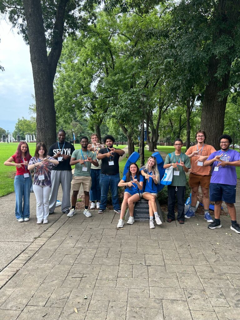 Students attending orientation posing for a photo at the blue horseshoe at MTSU with their Student Orientation Assistants.