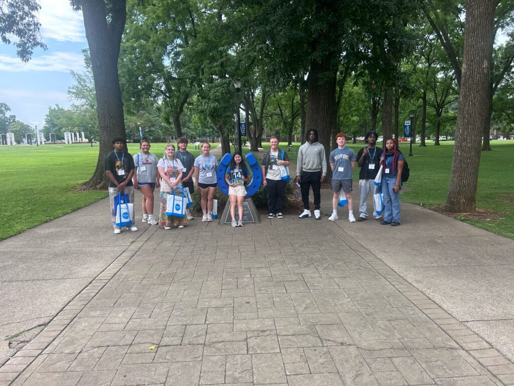 Students in Group 14 of orientation posing for a photo at the blue horseshoe at MTSU with their Student Orientation Assistant.