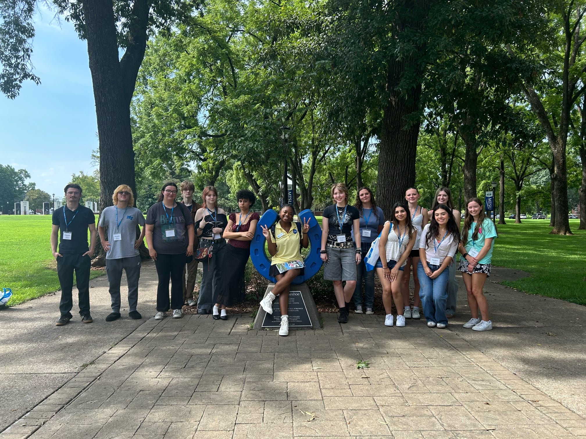 Students attending orientation posing for a photo at the blue horseshoe at MTSU with their Student Orientation Assistants.