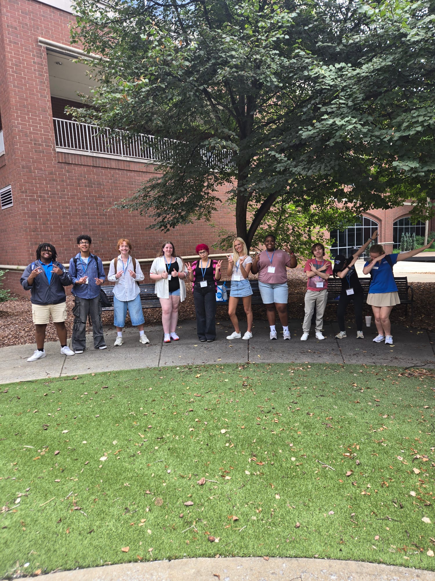 Students standing in the Business and Aerospace Building's courtyard, posing with their Student Orientation Assistants.
