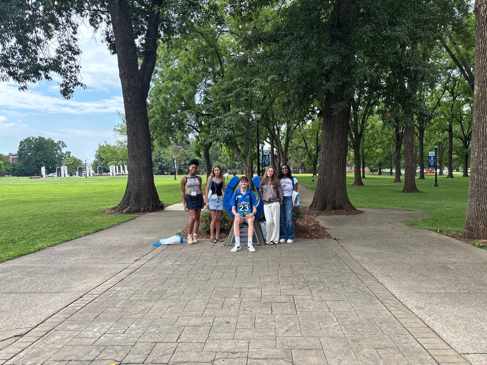 Students in Group 23 of orientation posing for a photo at the blue horseshoe at MTSU with their Student Orientation Assistant.
